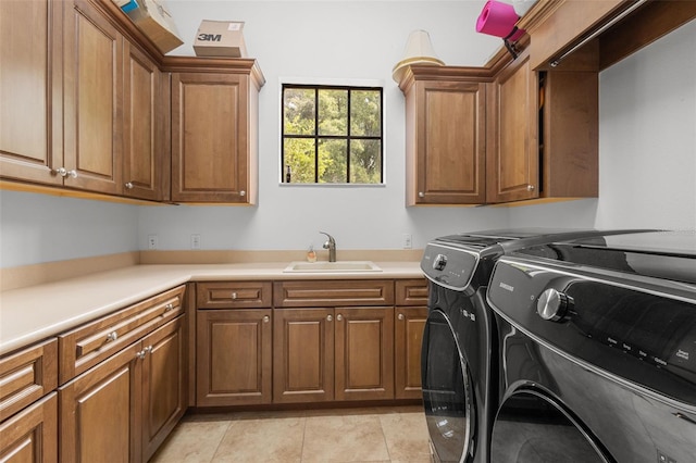 clothes washing area with cabinets, light tile patterned floors, sink, and washing machine and clothes dryer