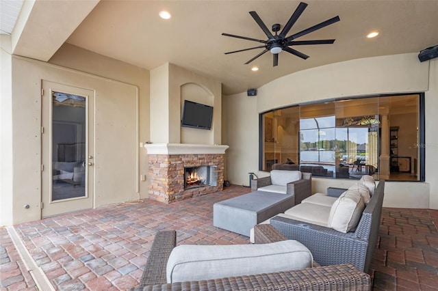 view of patio with ceiling fan and an outdoor stone fireplace