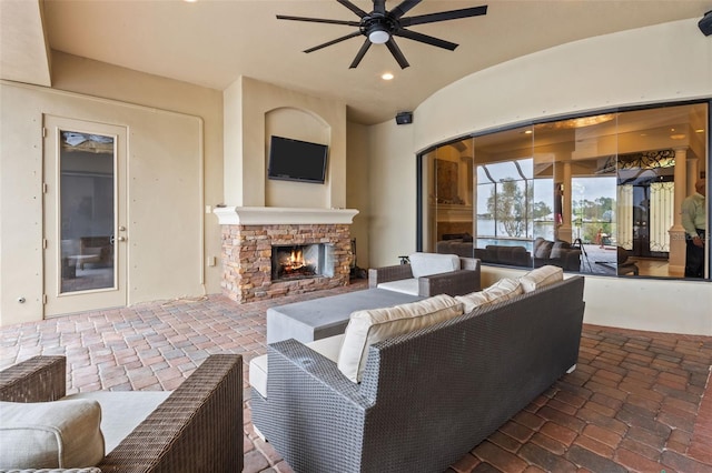 living room with an outdoor stone fireplace, ceiling fan, lofted ceiling, and brick ceiling