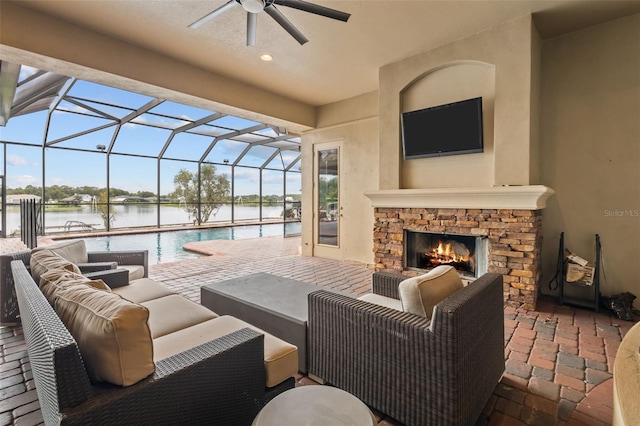 view of patio / terrace with an outdoor living space with a fireplace, glass enclosure, and a water view