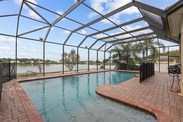 view of swimming pool with glass enclosure, a patio area, and a water view