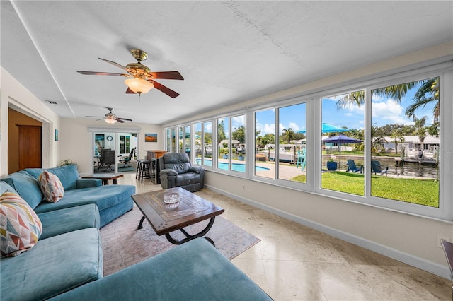 sunroom / solarium featuring ceiling fan