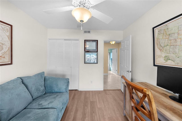 living room featuring ceiling fan and light wood-type flooring