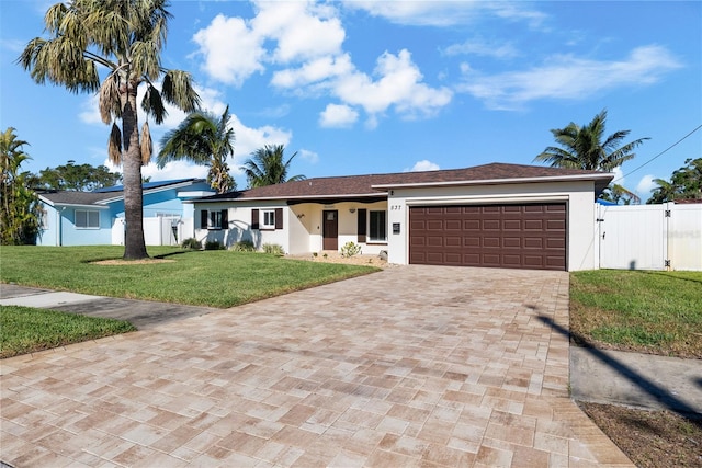 single story home featuring a garage and a front lawn