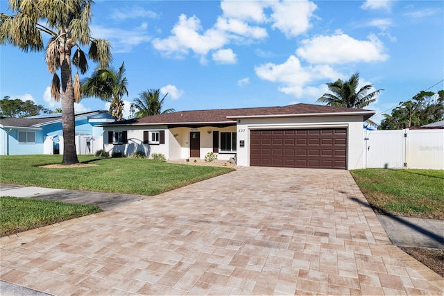 ranch-style house with a garage and a front lawn