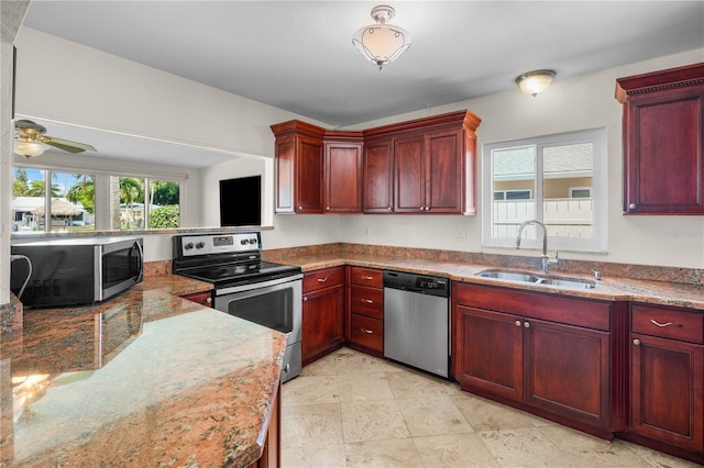 kitchen featuring ceiling fan, sink, light stone counters, and stainless steel appliances