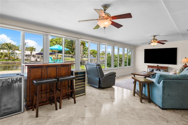 living room featuring a wealth of natural light, ceiling fan, and beverage cooler