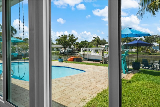 view of pool with a boat dock, a water view, and a patio area