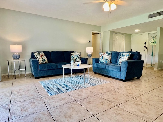 living room with ceiling fan, a textured ceiling, and tile patterned flooring