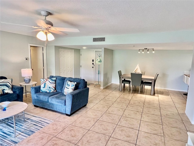 tiled living room with a textured ceiling and ceiling fan