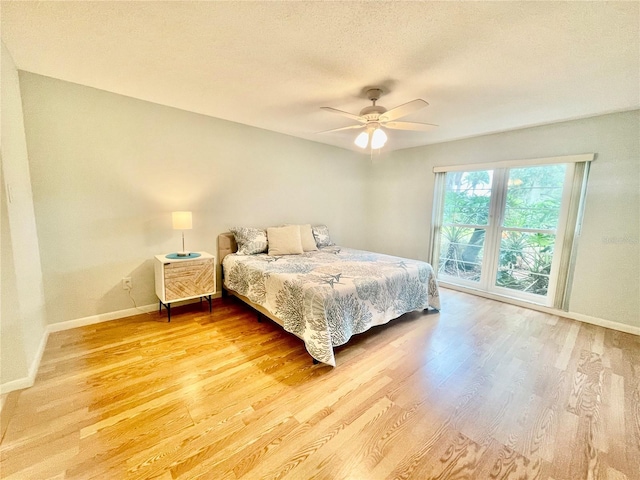 bedroom with a textured ceiling, ceiling fan, and hardwood / wood-style flooring