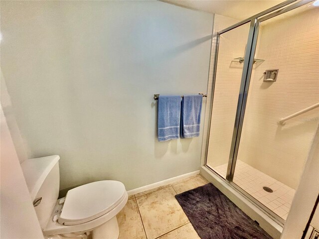 bathroom with toilet, tile patterned floors, and walk in shower