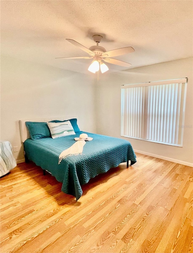 bedroom featuring a textured ceiling, ceiling fan, and hardwood / wood-style flooring