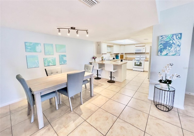 dining area featuring light tile patterned floors, baseboards, and visible vents