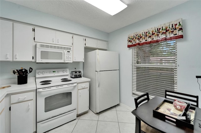 kitchen with light tile patterned floors, white appliances, white cabinetry, and a textured ceiling