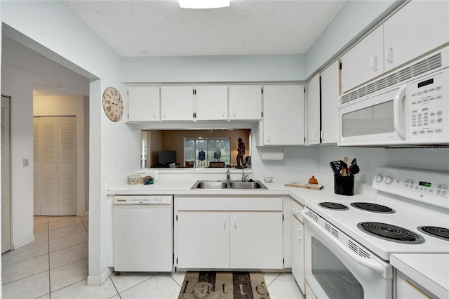 kitchen featuring a textured ceiling, sink, white cabinetry, white appliances, and light tile patterned floors