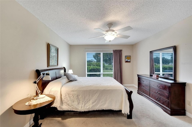 carpeted bedroom featuring multiple windows, ceiling fan, and a textured ceiling