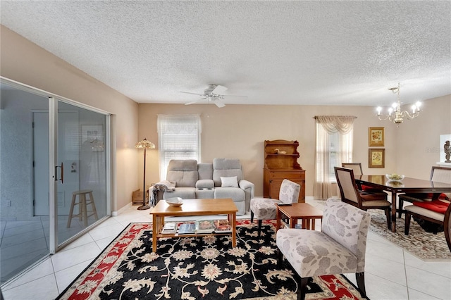 tiled living room with ceiling fan with notable chandelier and a textured ceiling