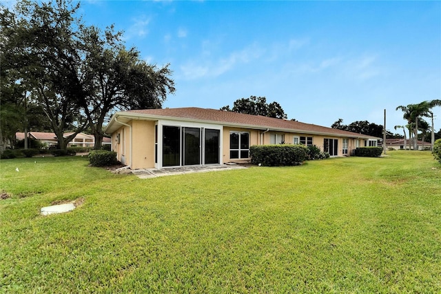 back of property featuring a lawn and a patio