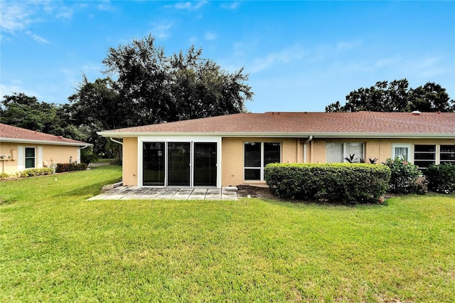 back of property featuring a patio area and a yard