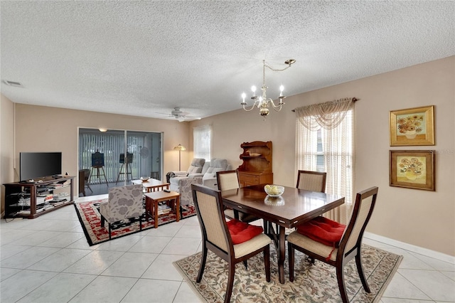 dining area with a textured ceiling, ceiling fan with notable chandelier, and light tile patterned floors