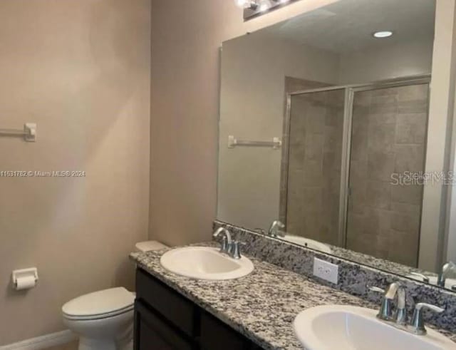 bathroom with vanity, toilet, and a shower with shower door