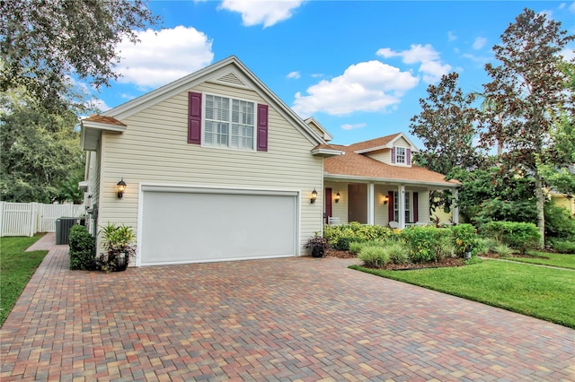 view of front of property with cooling unit, a garage, and a front lawn