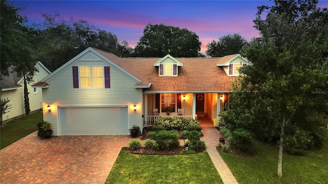 view of front of house featuring a lawn, a garage, and a porch