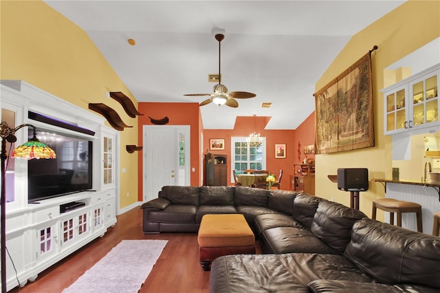 living room featuring lofted ceiling, dark wood-type flooring, and ceiling fan with notable chandelier