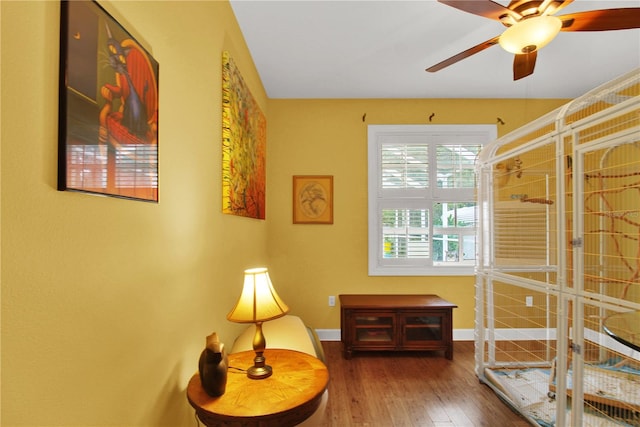 living area featuring hardwood / wood-style floors and ceiling fan