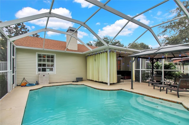 view of swimming pool featuring a patio area and a lanai