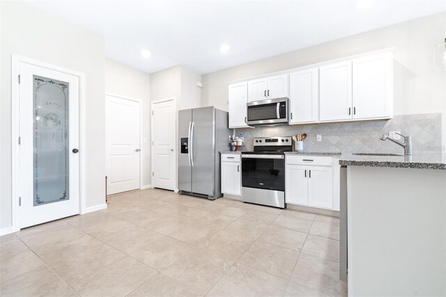 kitchen with backsplash, stainless steel appliances, sink, light stone countertops, and white cabinets