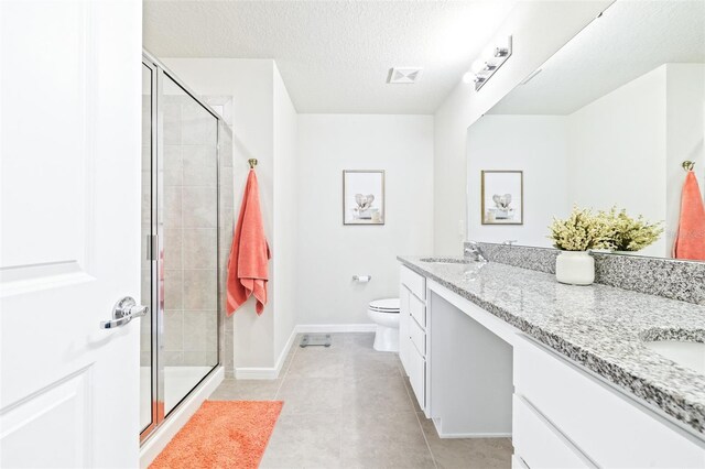 bathroom featuring tile patterned flooring, an enclosed shower, toilet, vanity, and a textured ceiling