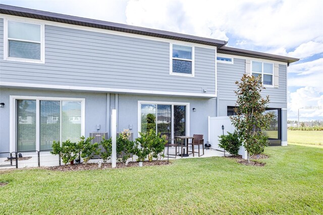 back of property featuring a yard and a patio