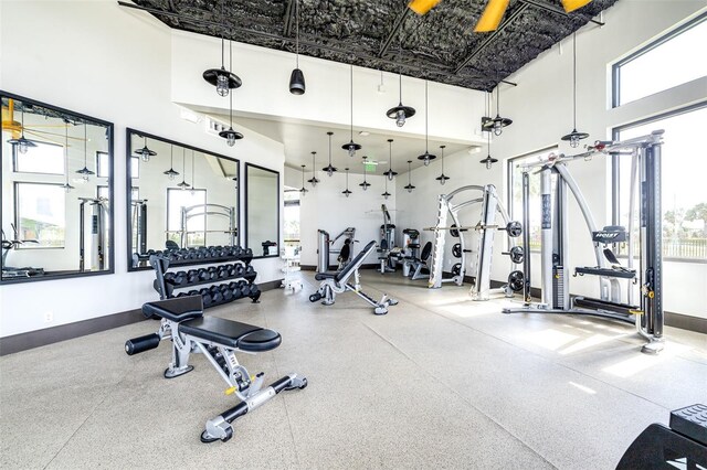 workout area with plenty of natural light and a towering ceiling