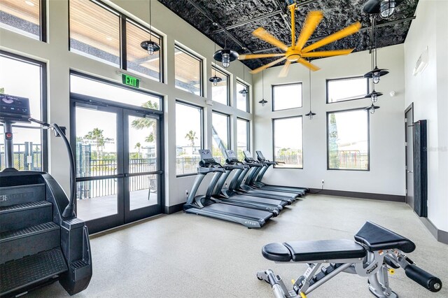 exercise room featuring a high ceiling, ceiling fan, and french doors