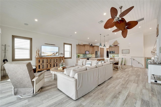 living area with lofted ceiling, recessed lighting, visible vents, baseboards, and light wood finished floors