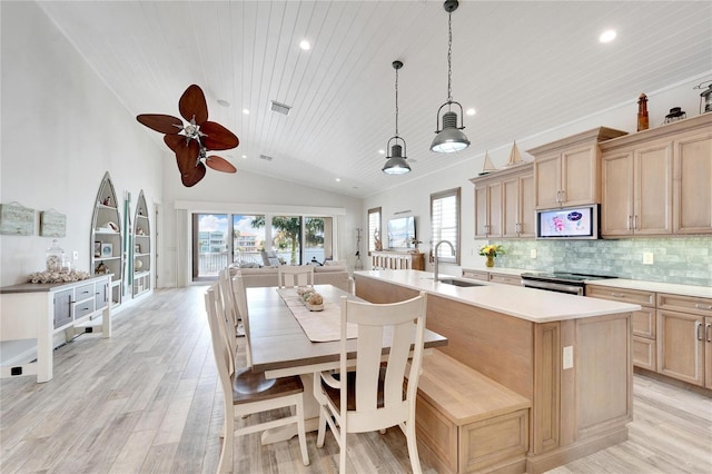 kitchen featuring light brown cabinetry, vaulted ceiling, appliances with stainless steel finishes, sink, and ceiling fan