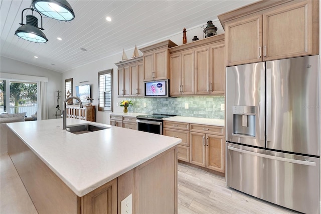 kitchen featuring a center island with sink, light wood-type flooring, appliances with stainless steel finishes, and lofted ceiling