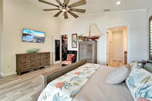 bedroom with ornamental molding, wood finished floors, visible vents, and baseboards