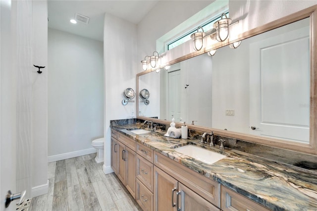 bathroom with vanity, toilet, and hardwood / wood-style flooring