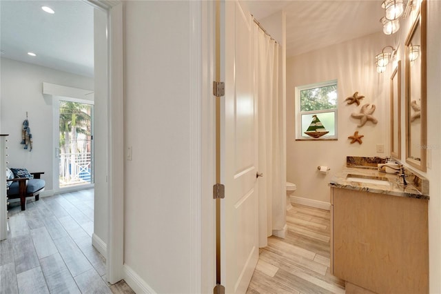 bathroom featuring vanity, toilet, a wealth of natural light, and hardwood / wood-style floors