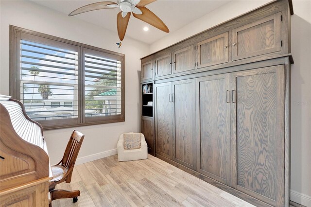 home office featuring light hardwood / wood-style flooring and ceiling fan