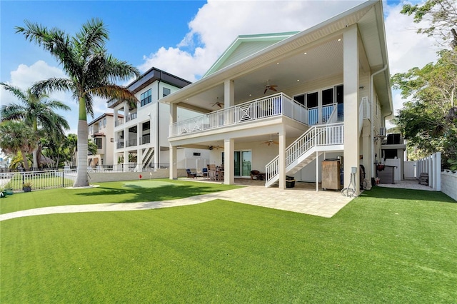 rear view of property featuring a patio area, stairs, fence, and a yard