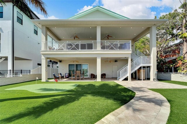 back of property with a yard, ceiling fan, and a patio