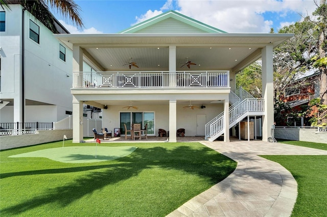 rear view of property with a patio, a balcony, fence, stairs, and a lawn