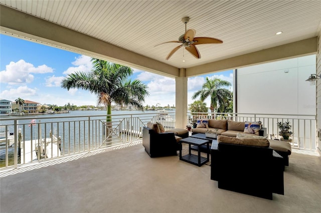 view of patio / terrace featuring a balcony, an outdoor living space, a water view, and ceiling fan