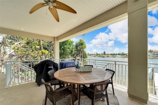 view of patio / terrace featuring a balcony, ceiling fan, and a water view