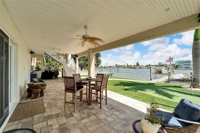 view of patio / terrace with ceiling fan and a water view