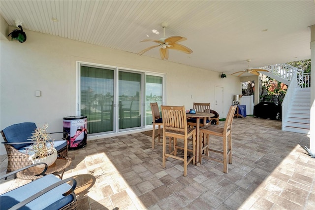 view of patio with ceiling fan, stairs, and outdoor dining area